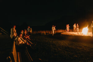 Wedding guests at evening bonfire
